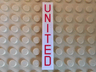 Tile 1 x 6 with Red 'UNITED' Pattern