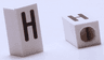 Tile, Modified 1 x 2 x 5/6 Stud Hole in End with Black Capital Letter H Pattern