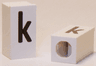Tile, Modified 1 x 2 x 5/6 Stud Hole in End with Black Lowercase Letter k Pattern